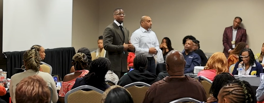 Breakout session with speakers standing among seated attendees